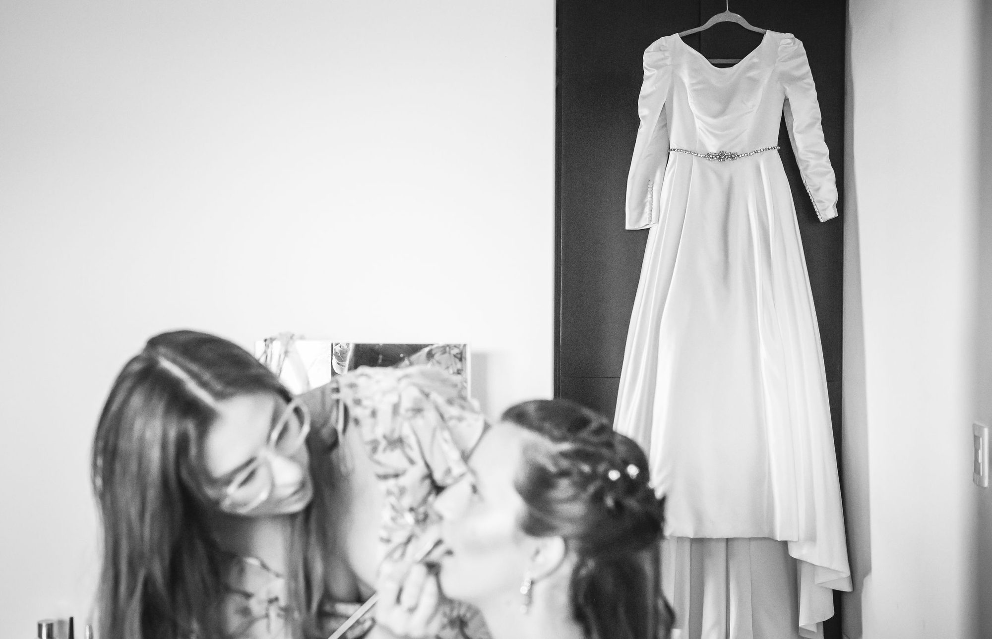 Novia y amiga riendo, con el vestido colgado detrás