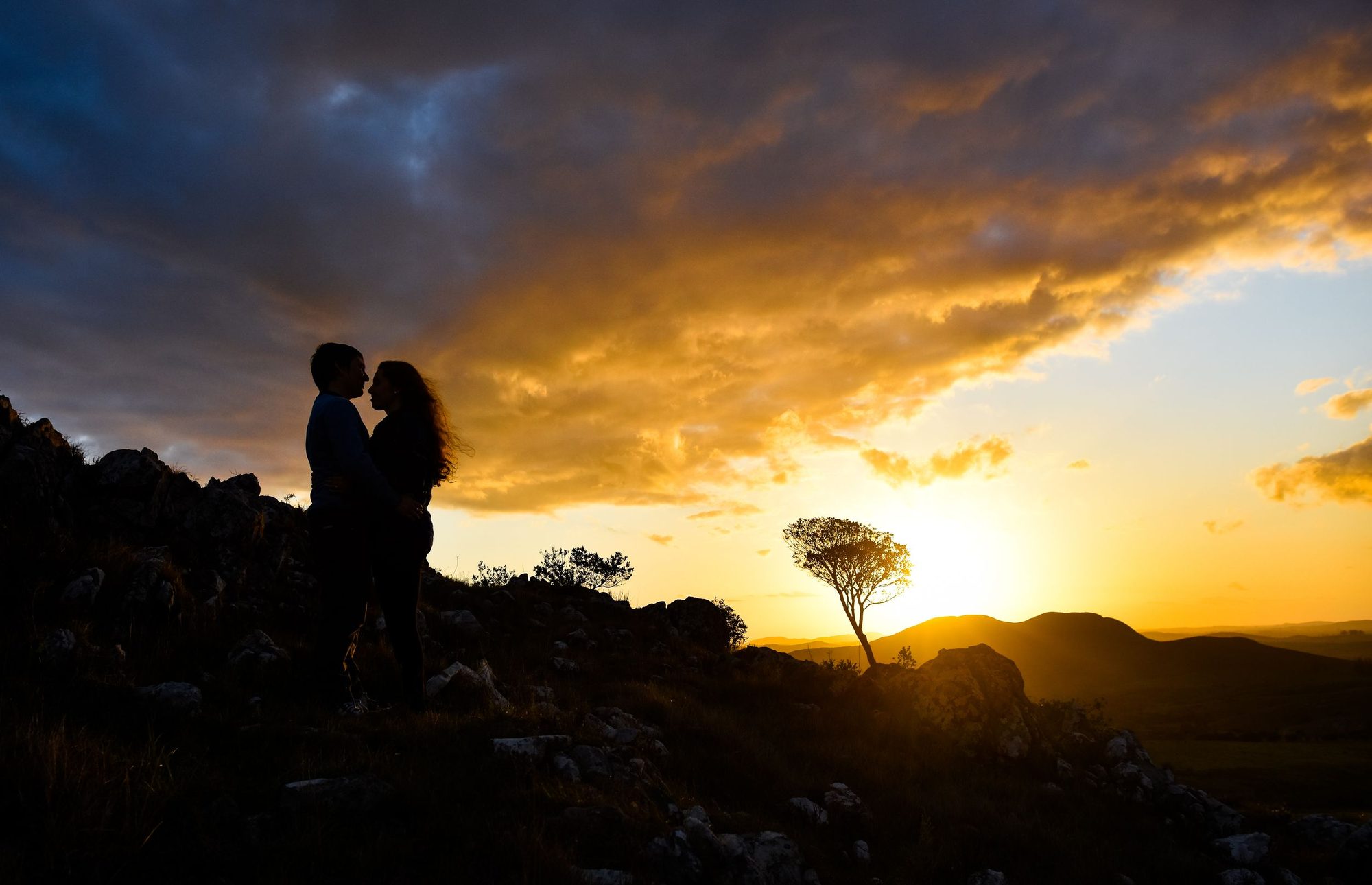 Silueta de una pareja sobre las sierras al atardecer